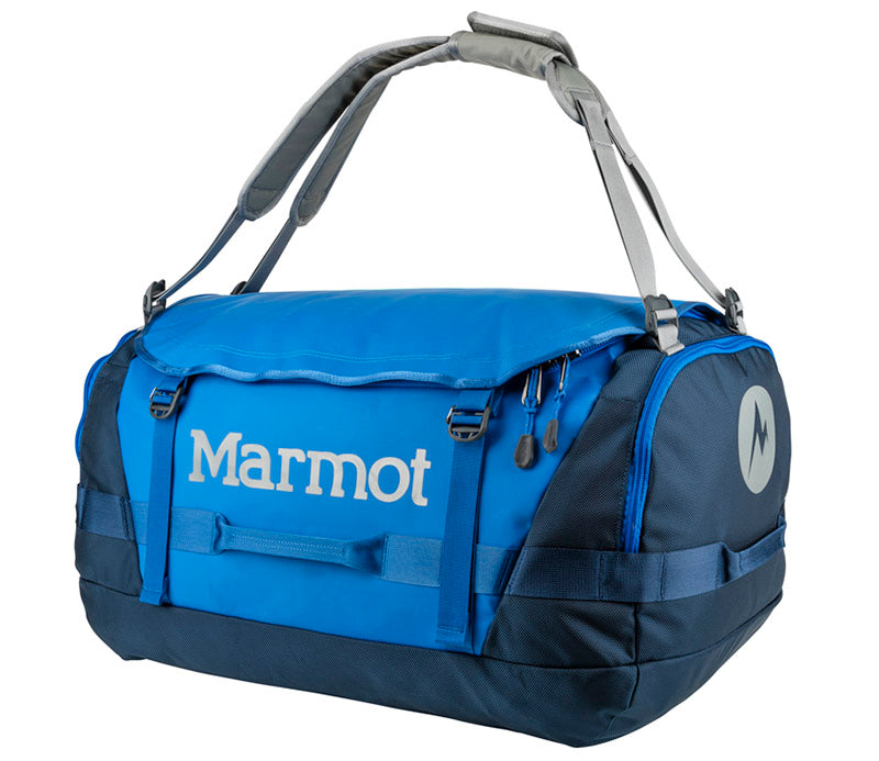A blue and dark gray Marmot Duffle Bag by Nomadic, featuring reinforced handles, shoulder straps, and zipper compartments—ideal for any trip. The Marmot logo appears in white on the side. Perfect as Event merch. Premium Camping and Glamping