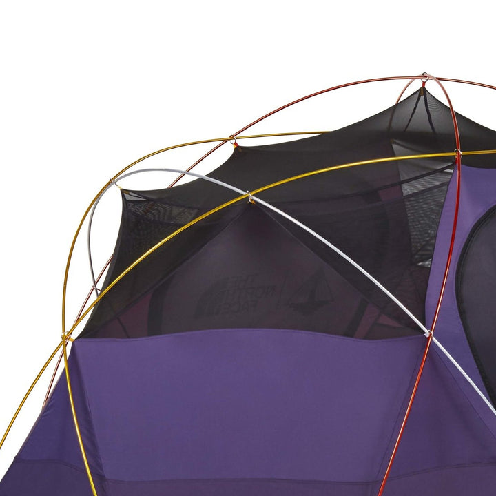 Nomadic North Face Oval Intention | Event Collaboration tent - Used, features a purple and black design with a unique mesh upper section and intersecting red, yellow, and white poles; shown on a white background.