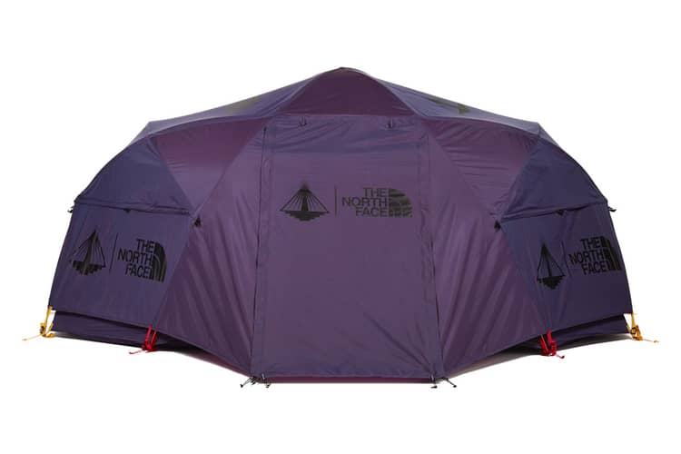 A large, purple, dome-shaped Nomadic North Face Oval Intention | Event Collaboration tent (used) with multiple entrances, securing points with red and yellow straps, and several panels showing The North Face logo, set against a white background.